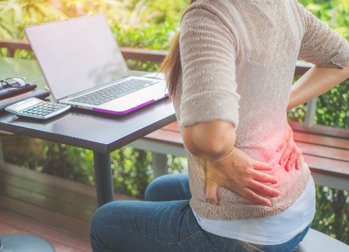 Woman experiencing back pain from poor posture